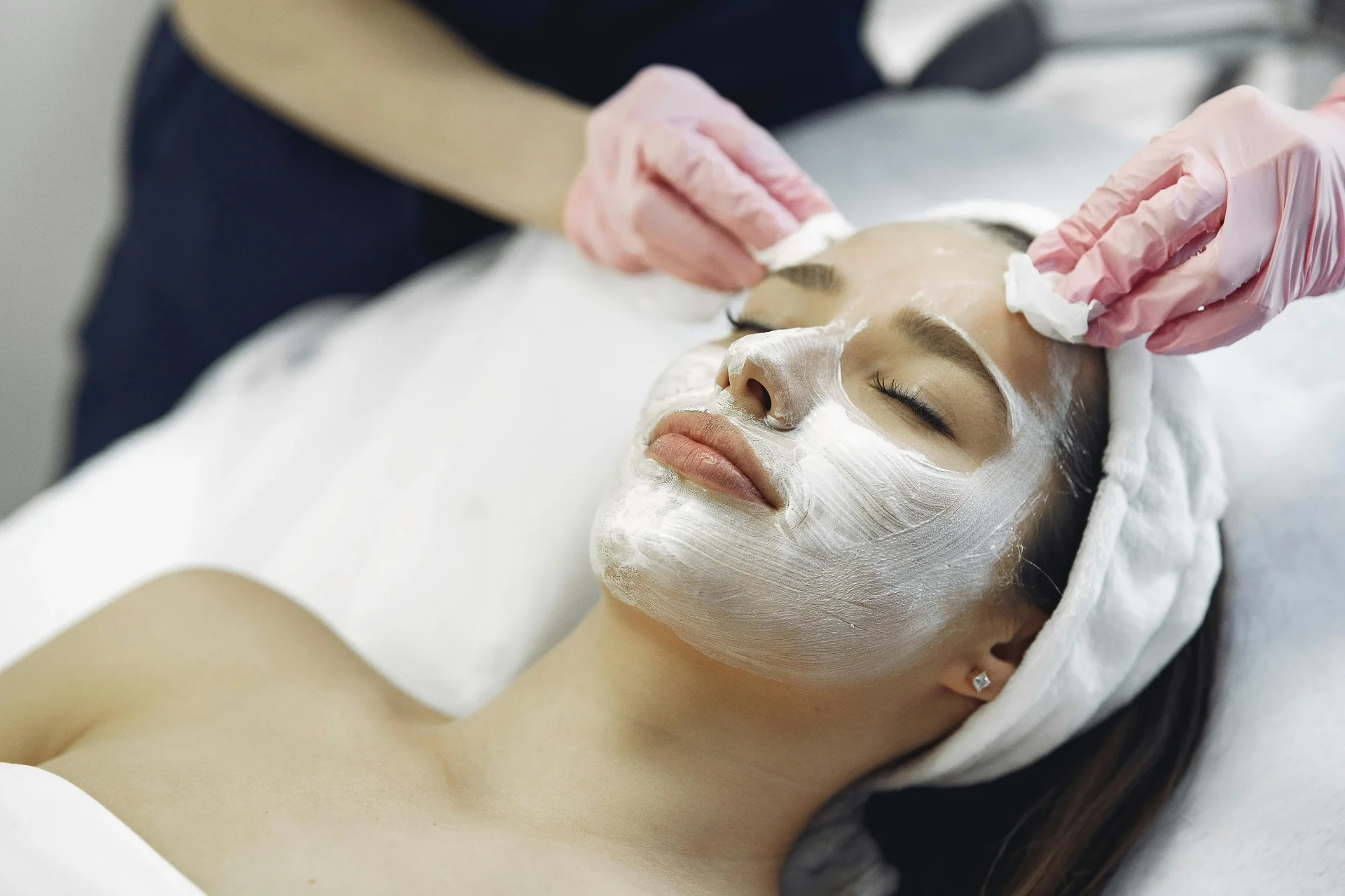 esthetician removing girls facial mask